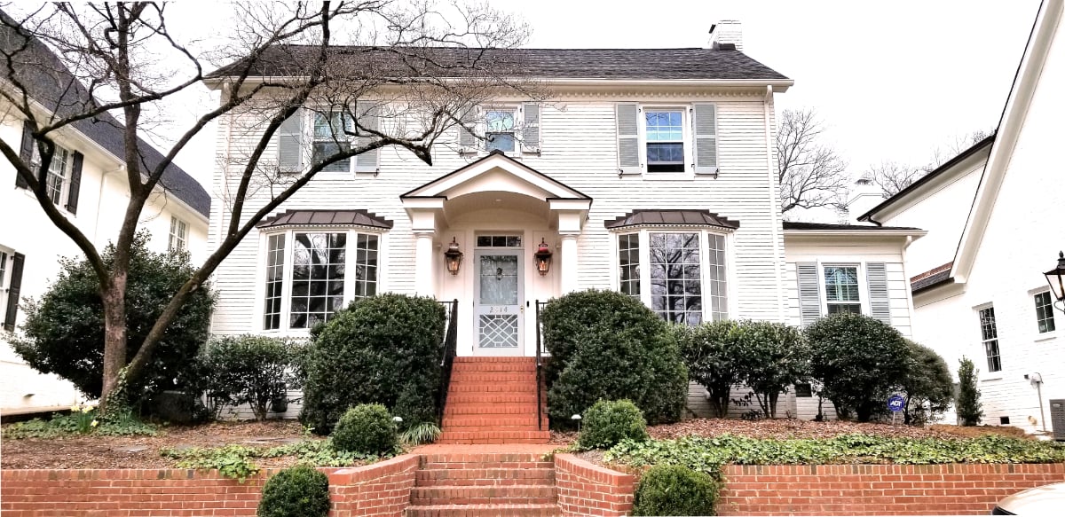 Covered front porch with traditional columns and gas lanterns